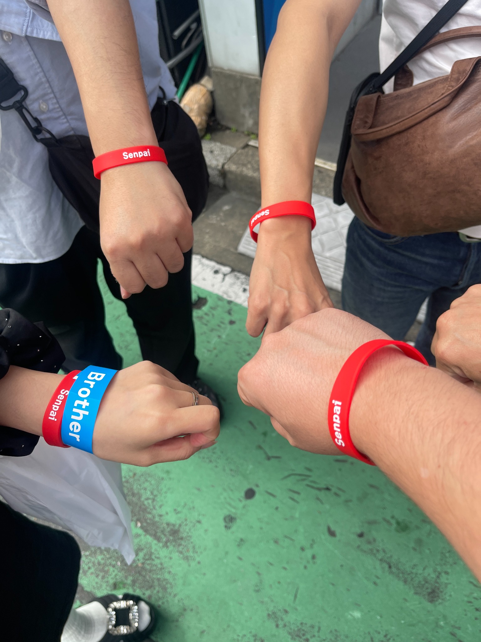 SenpaiとBrotherのリストバンドを着けた参加者の手